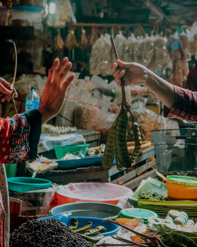Pemilik usaha kecil sedang melayani pelanggan di pasar tradisional